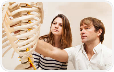 chiropractor and patient looking at a skeleton